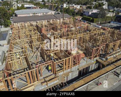 Aerial view of a new building being framed by carpenters. Worker builder working on building structure on construction site Stock Photo