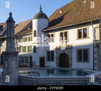 Historic city centre of Brugg AG, Switzerland. The medieval fountain and buildings in the late afternoon sunlight Stock Photo