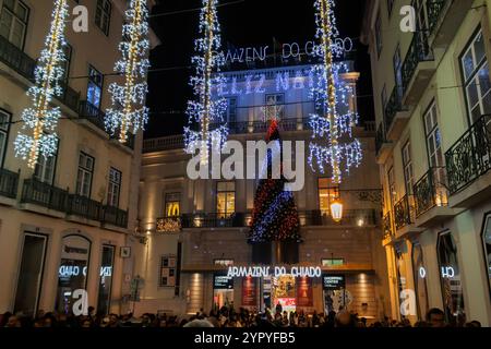 Lisbon, Portugal - Christmas lights and decorations in Chiado historic buildings. People walking in the street downtown at night Stock Photo