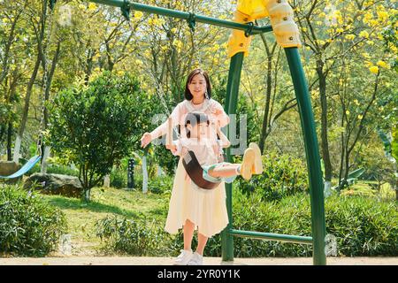 Mother and son swinging in the park Stock Photo