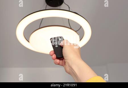 LED ceiling light with smart remote control. Energy saving. Clean planet and environmental protection.  Stock Photo