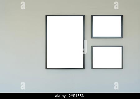 Picture frames on a white wall in a minimalist interior. Picture frame on a wall black frame. Blank Mockup. Blank frames on the wall at art gallery Stock Photo