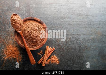Aromatic cinnamon powder and sticks with spoon on grey background close up Stock Photo