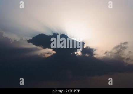 Sunset sky, sun rays from behind the clouds Stock Photo