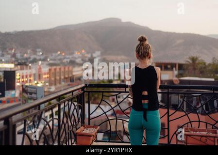 Woman Admiring Sunset View from a Balcony in Morocco Stock Photo