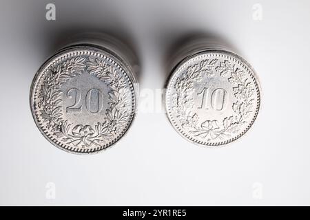 A stack of 20 Rappen and 10 Rappen Swiss Franc currency coins. Top view, isolated on white, close up shot, no people. Stock Photo