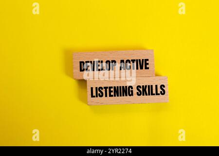 Develop active listening skills message written on ripped torn yellow ...