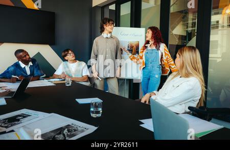 A diverse team engaged in a collaborative meeting in a modern office, discussing color theory and fashion concepts with passion and creativity. Stock Photo