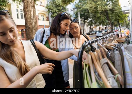 Female friends discussing while doing shopping at street market Stock Photo