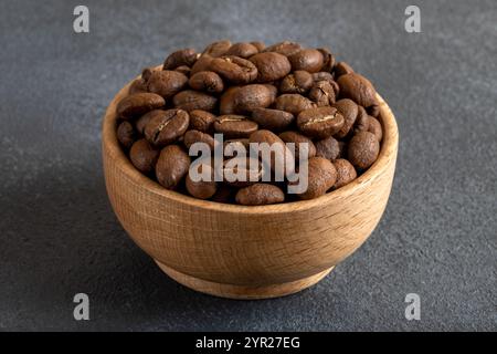 A bowl full of roasted coffee beans on gray background Stock Photo