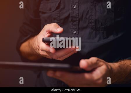 Data synchronization, man using smartphone and digital tablet computer to sync data, selective focus Stock Photo
