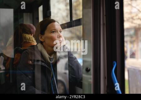 Sad and contemplative woman riding a dirty public transportation bus ...