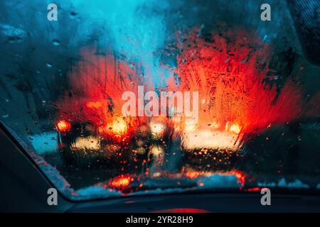 Traffic lights on rainy night, bokeh background with selective focus Stock Photo