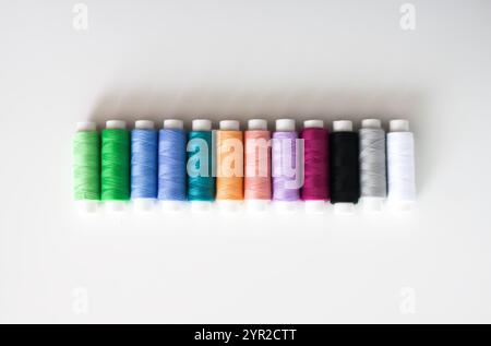 Many colorful sewing threads on light background. Stock Photo