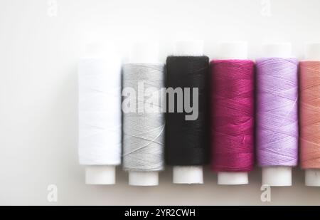 Many colorful sewing threads on light background. Stock Photo