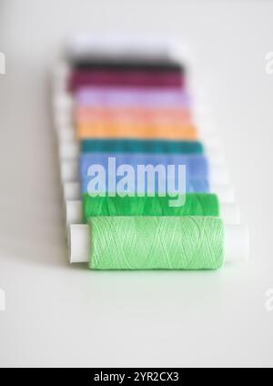 Many colorful sewing threads on light background. Stock Photo