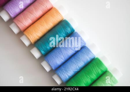 Many colorful sewing threads on light background. Stock Photo