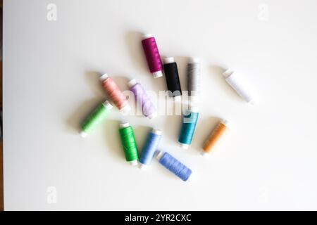 Many colorful sewing threads on light background. Stock Photo