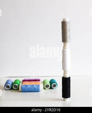 Many colorful sewing threads on light background. Stock Photo