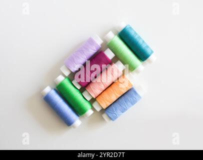 Many colorful sewing threads on light background. Stock Photo