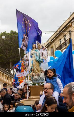 Cospicua, Malta - December 1st 2024. Religious Procession Celebrating a Feast Day with Statues and Banners Stock Photo