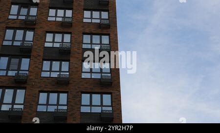 brown brick high rise building view from bottom to top against light blue sky, architectural background with modern residential building Stock Photo