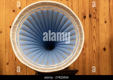 Decorated blue gramophone speaker is over wooden wall, close up photo Stock Photo