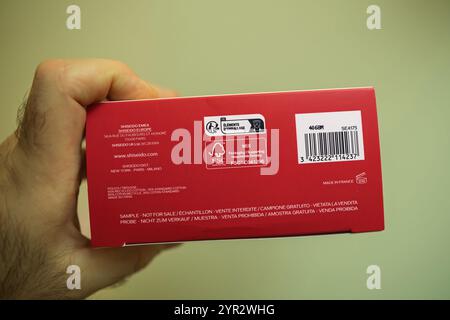 Paris, France - Dec 1, 2024: Close-up of a Shiseido cosmetic pouch box with FSC-certified packaging, manufacturing details, barcode, and sustainability information, held in a hand Stock Photo