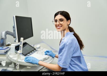 A dedicated gynecologist in a lab coat smiles while using ultrasound equipment. Stock Photo