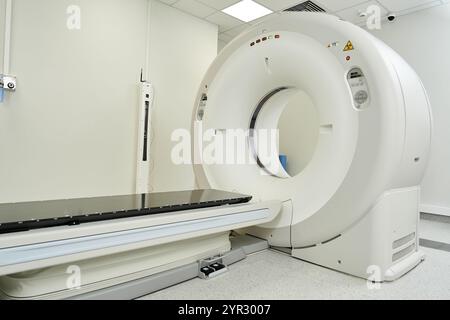 Bright, modern hospital room showing an MRI machine ready for diagnostic testing and patient care. Stock Photo