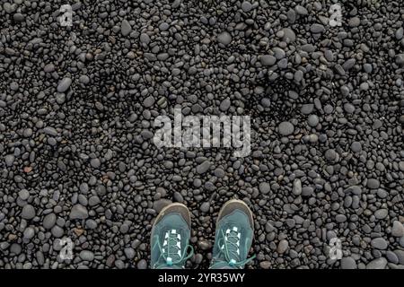 A pair of boots on the black volcanic rocks at an Icelandic beach Stock Photo