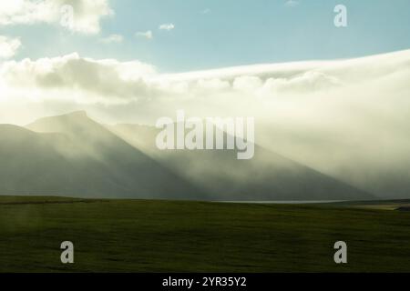 Icelandic mountains shrouded in clouds, creating a mystical atmosphere Stock Photo