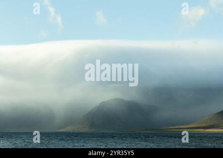 Icelandic mountains shrouded in clouds, creating a mystical atmosphere Stock Photo