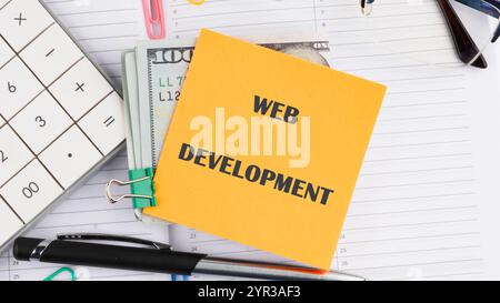 Concept word WEB DEVELOPMENT it is written on a sticker on the background of an open notebook. Stock Photo