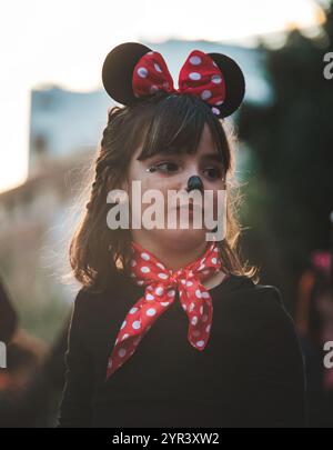 The image shows a child dressed in a costume that includes what looks like Mouse ears, commonly associated with the iconic Disney character Minnie Stock Photo