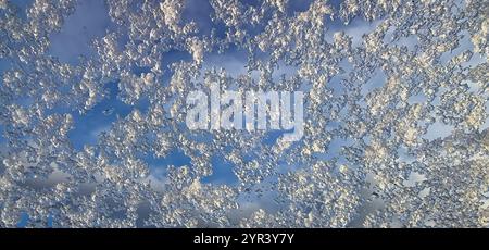 Melted snowflakes on a skylight with blue sky in the background Stock Photo