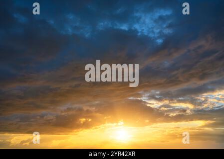 Real sky texture background with bright sun at sunset. Dramatic red, orange and purple clouds. High resolution photography perfect for sky replacement Stock Photo