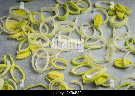 Background, leeks cut into rings on parchment or baking paper. High quality photo Stock Photo