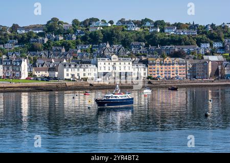 Boats moored in Oban Bay with commercial building on Corran Esplanade on Oban seafront in Argyll and Bute, Scotland, UK Stock Photo