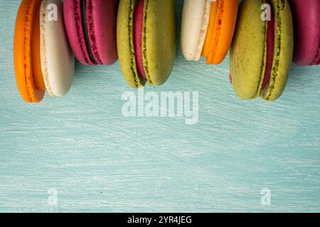 Multi-colored macaroons are stacked. Cherry, pistachio and mango macaroons on a light blue background. Copyspace, Place for text. High quality photo Stock Photo