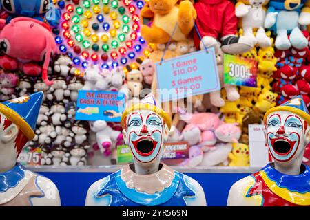 Bundaberg Queensland Australia - May 30 2024: Laughing clowns in sideshow alley, prizes in background, Bundaberg agricultural show Stock Photo