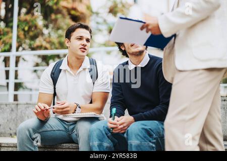 Students collaborating with professor outdoors on a sunny day Stock Photo