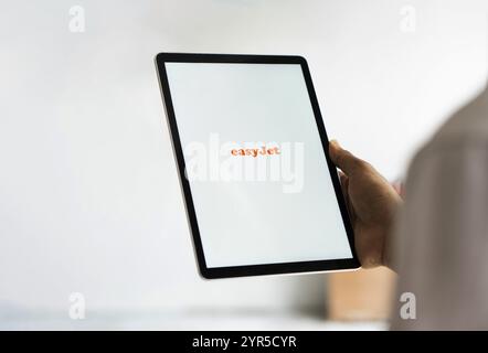 EasyJet logo is displayed on iPad. EasyJet plc is a British multinational low cost airline group. Stock Photo