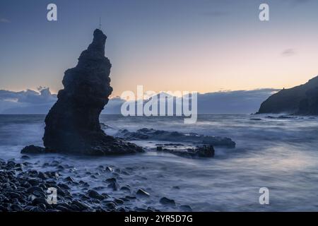 Before sunrise on the beach at Playa de La Caleta. Rocks and sea. Tenerife and the Teide in the background. Long exposure. La Gomera, Canary Islands, Stock Photo