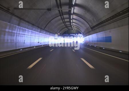 Modern, well-lit motorway tunnel with blue illuminated walls and a clear asphalt road, Switzerland, Europe Stock Photo