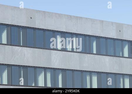 Modern concrete building with rows of reflective glass windows Stock Photo