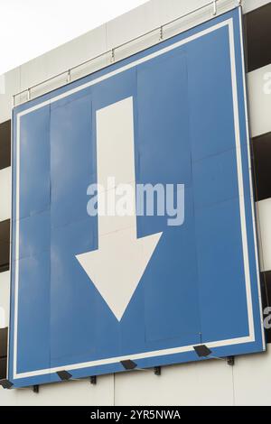 Sign huge white directional arrow on blue background Stock Photo