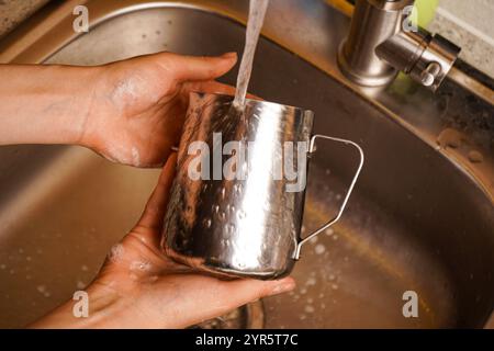 A quick rinse between uses ensures no old milk affects the flavor of the next drink. Stock Photo