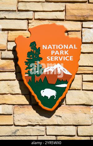 Mancos, CO, USA - June 16, 2024; National Park Service arrowhead logo in closeup on pale stone wall Stock Photo