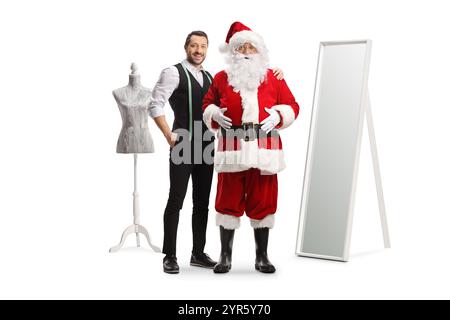 Santa Claus at a tailors workshop trying on a costume isolated on white background Stock Photo